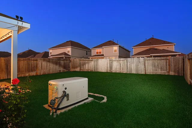 a view of a backyard with plants barbeque grill and wooden fence