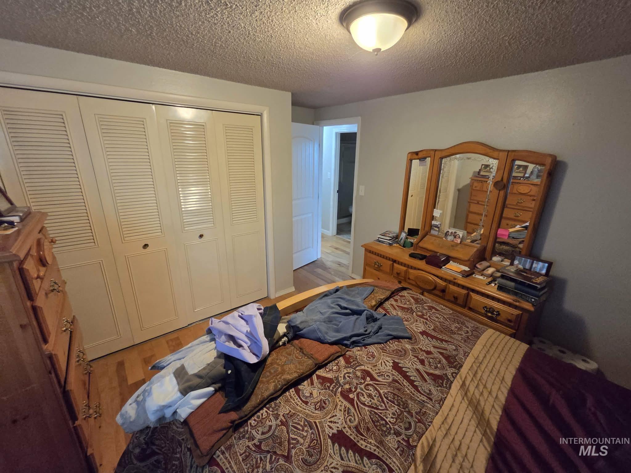 1535 Sunnyside Road Weiser, ID 83672 - Photo 14 of 26 Wood-finish flooring, white louvered bifold closet doors, and flush-mount ceiling lighting
