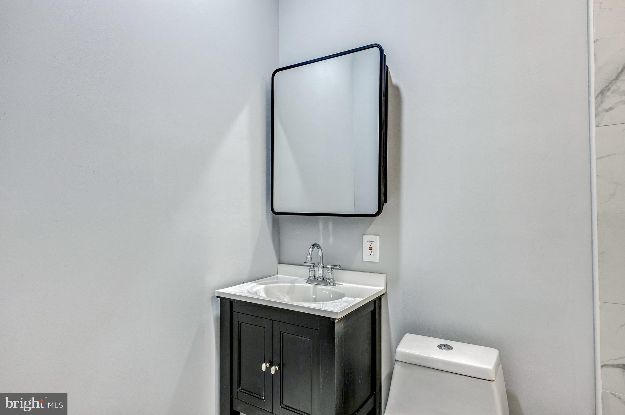 3816 Bonner Road Baltimore, MD 21216 - Photo 16 of 36 a bathroom with a toilet sink and mirror