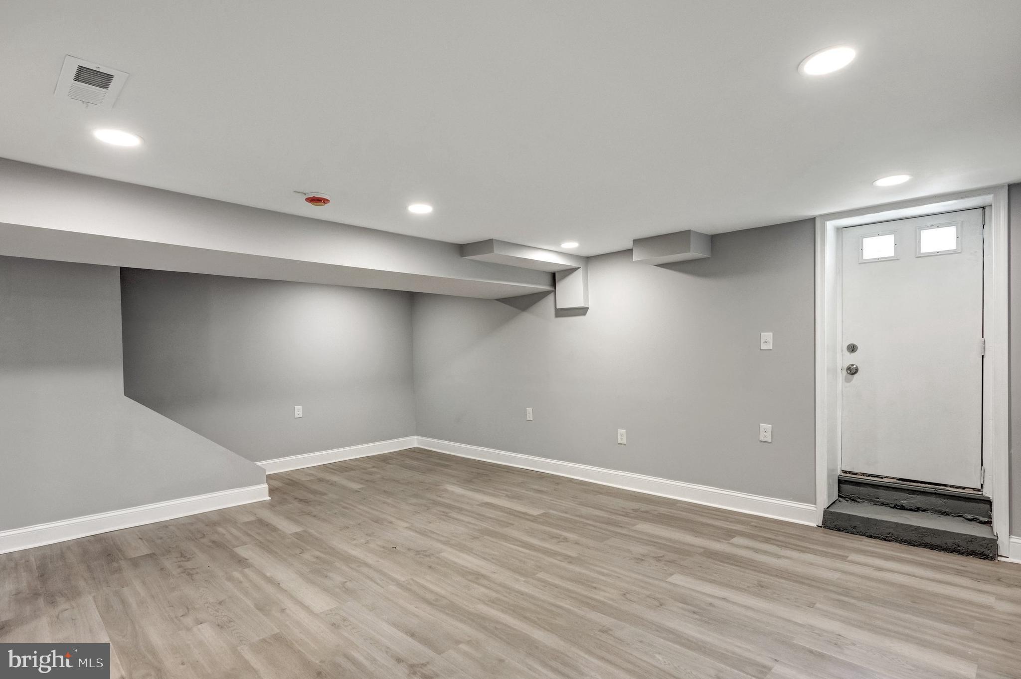 3816 Bonner Road Baltimore, MD 21216 - Photo 30 of 36 an empty room with wooden floor and windows