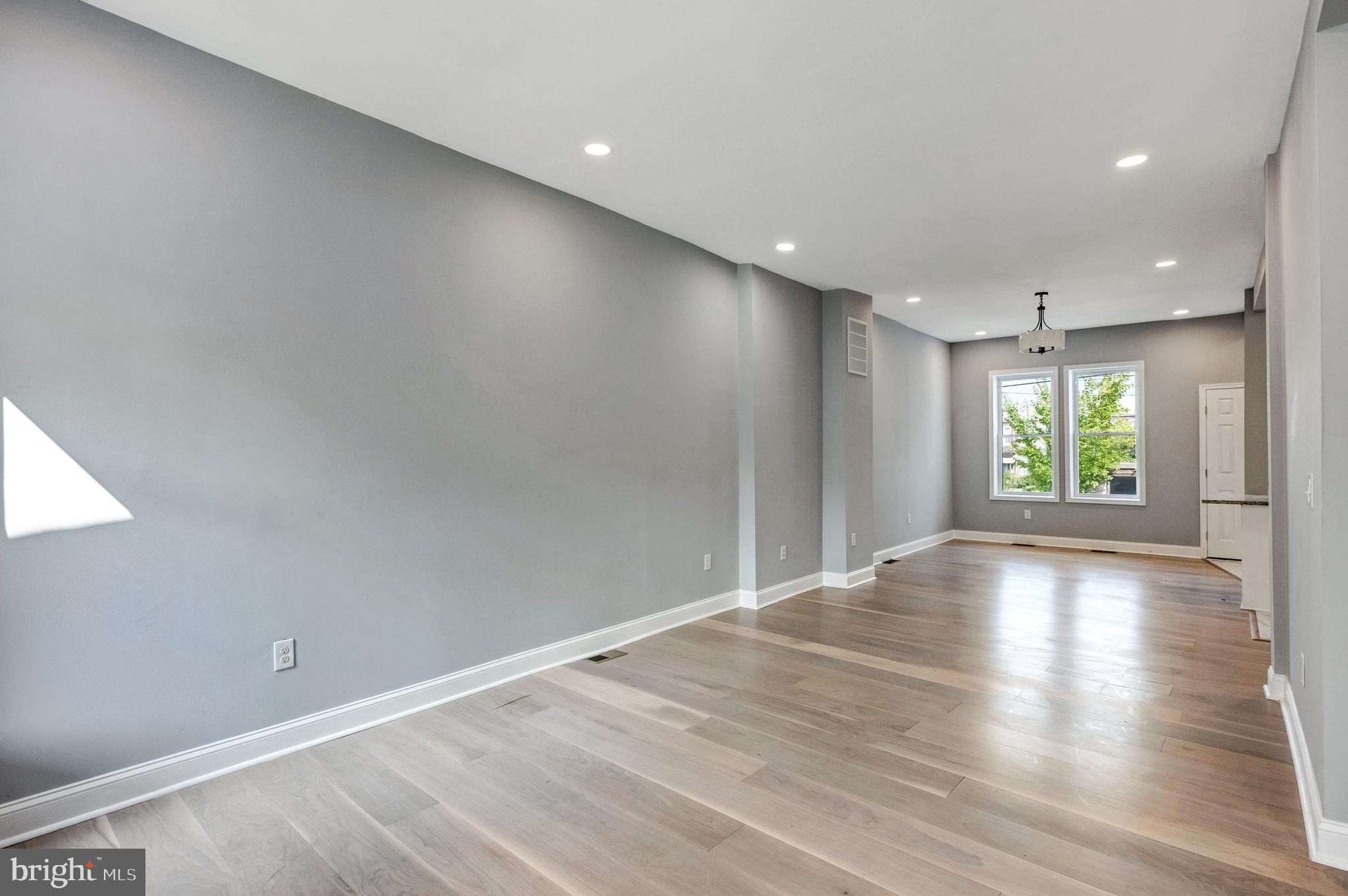 3816 Bonner Road Baltimore, MD 21216 - Photo 5 of 36 an empty room with wooden floor and windows