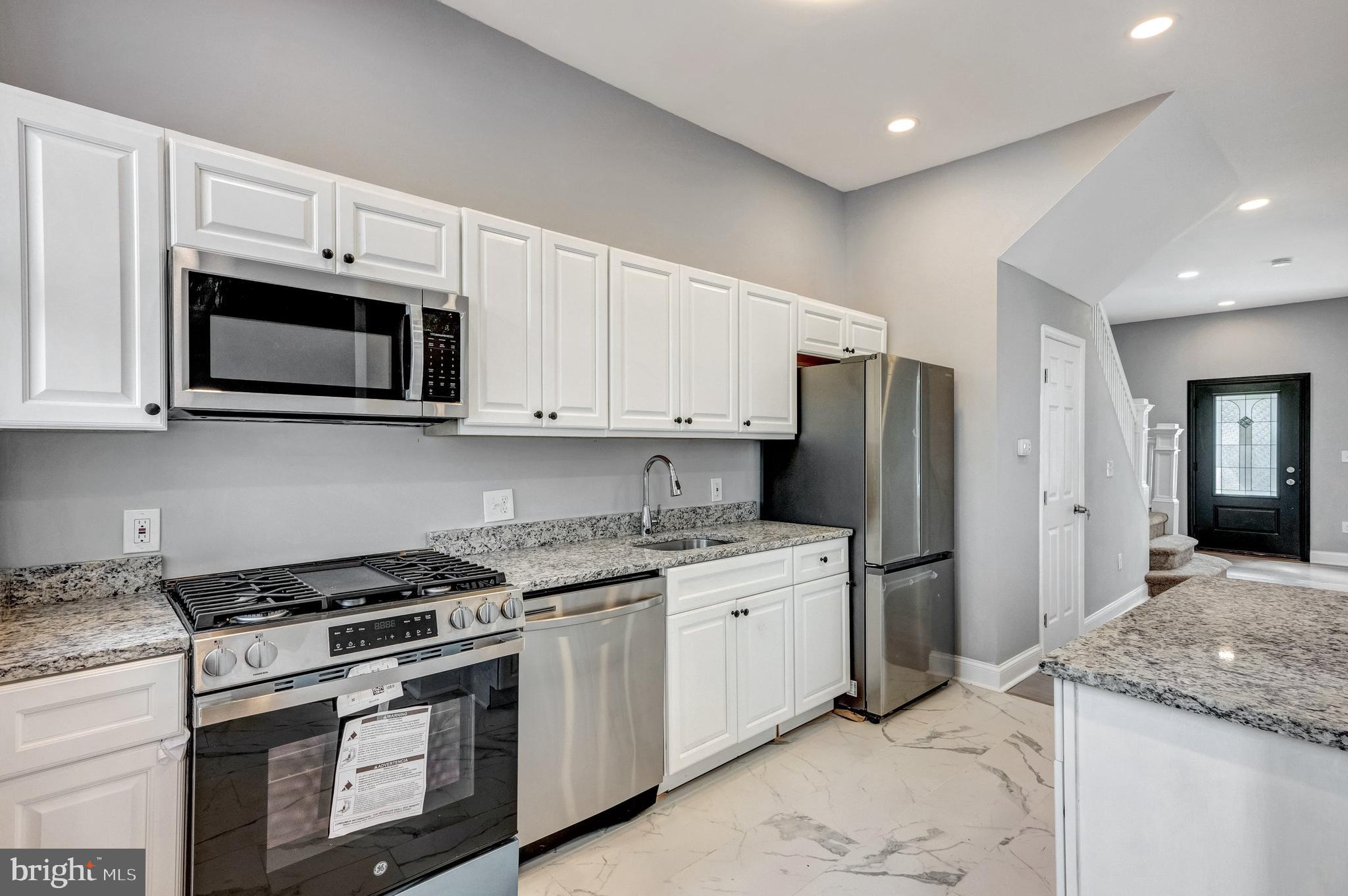 3816 Bonner Road Baltimore, MD 21216 - Photo 9 of 36 a kitchen with stainless steel appliances granite countertop a stove a refrigerator and a microwave