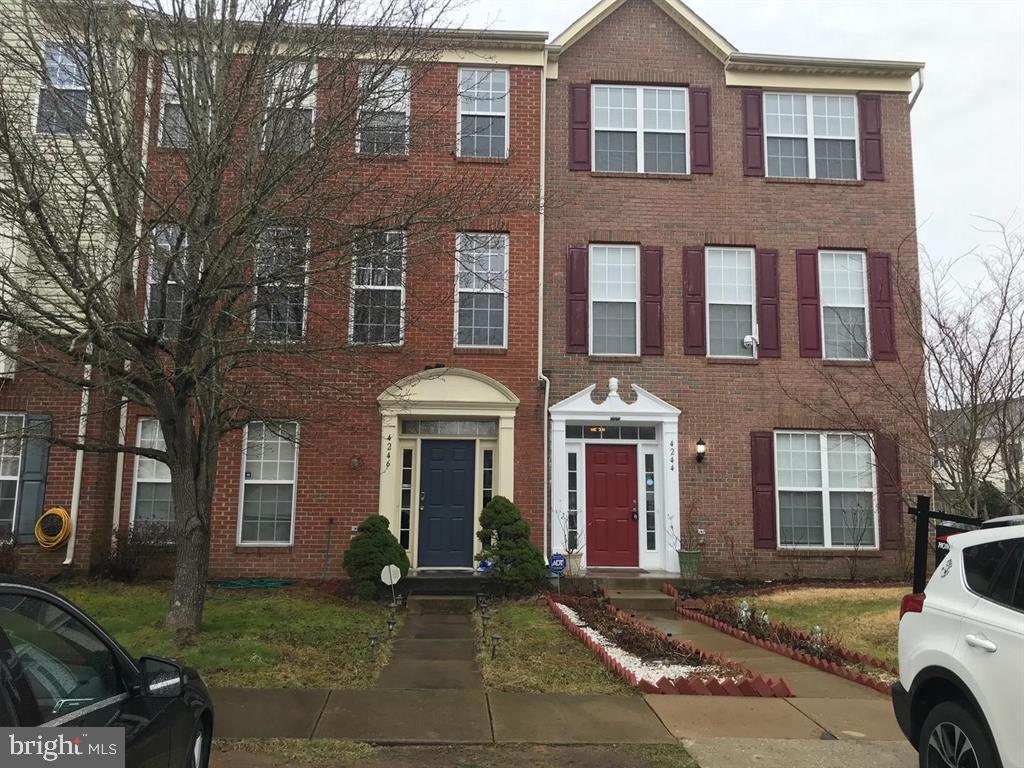4244 La Mauricie Loop Dumfries, VA 22025 - Photo 2 of 16 a front view of a house with garden and parking