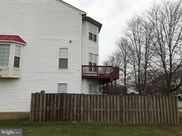 a view of a house with a small yard and a large tree