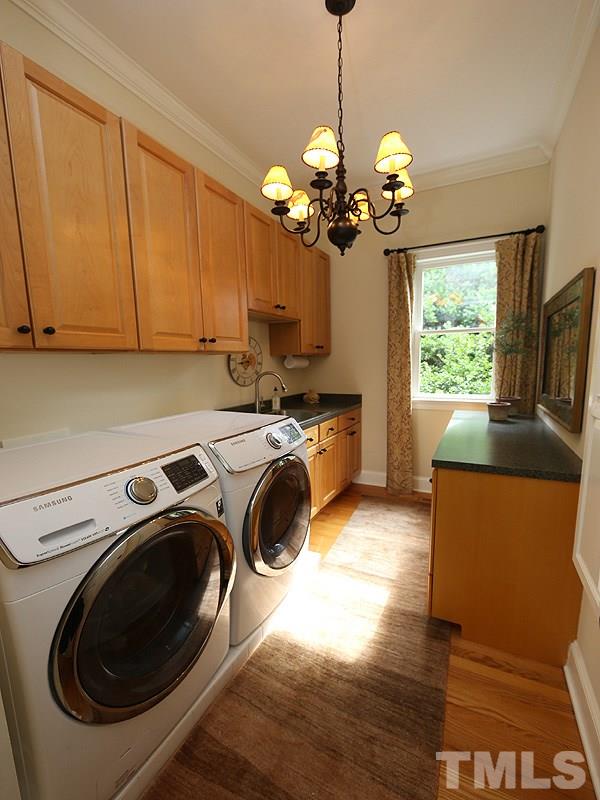 4417 Harbourgate Drive Raleigh, NC 27612 - Photo 11 of 25 The main floor laundry room is conveniently located near the garage door. There are both upper and lower cabinets, a sink and counter space. In addition, there is a fold out ironing board. Even this room is cozy & decorated.