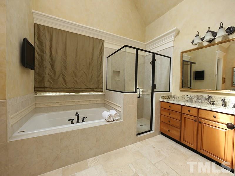 4417 Harbourgate Drive Raleigh, NC 27612 - Photo 13 of 25 WOW! The master bath has heated tile floors and a heated towel rack, a large walk-in shower and a whirlpool tub, his and her vanities with granite counters. There is a separate room for the commode.