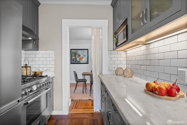 a kitchen with stainless steel appliances wooden floor a stove and a dining table