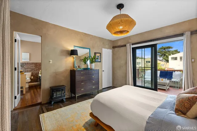 a bedroom with a bed and dresser with mirror