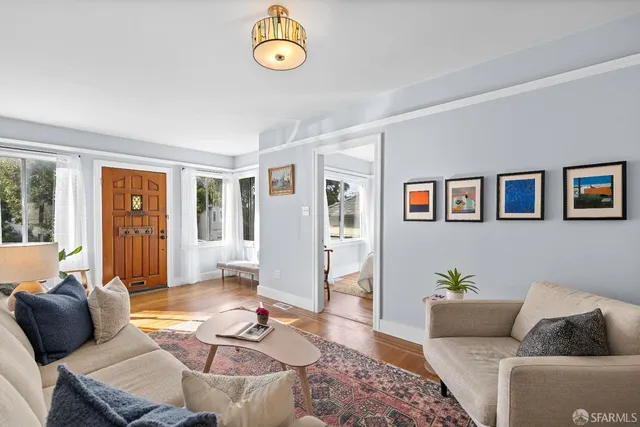 a living room with furniture and wooden floor