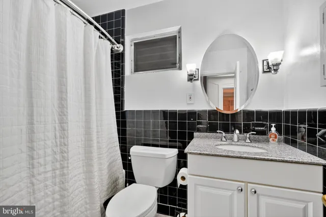 a bathroom with a sink toilet mirror and vanity