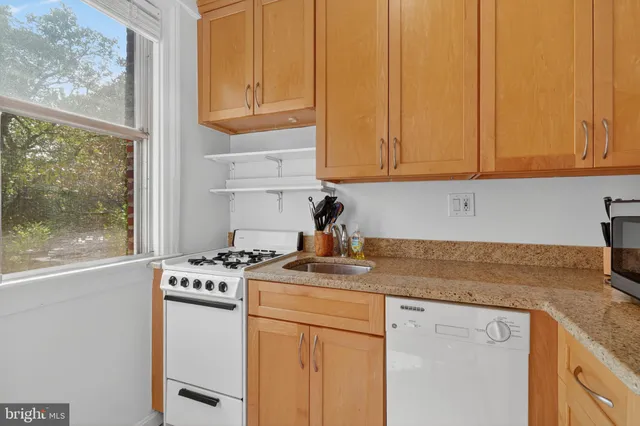 a kitchen with stainless steel appliances granite countertop a sink stove and cabinets