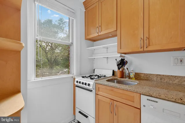 a kitchen with granite countertop cabinets stainless steel appliances and a counter space