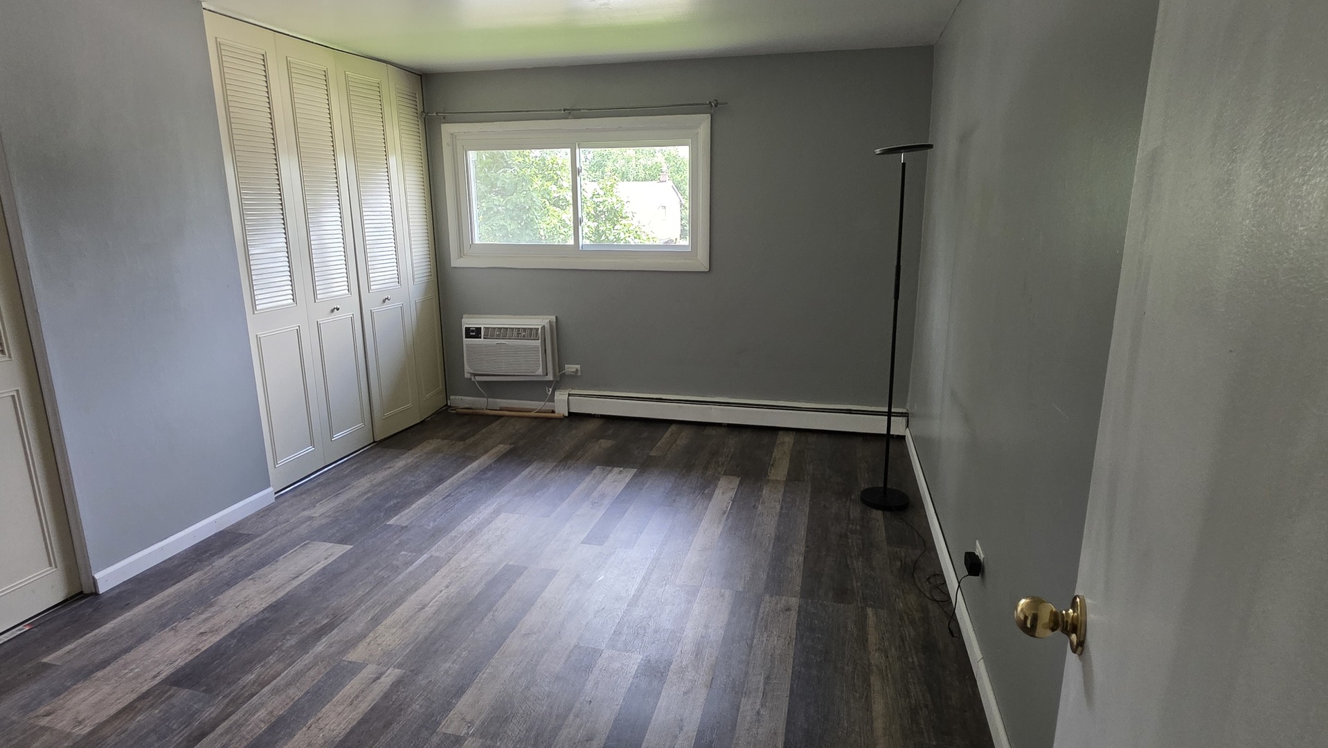 9446 Dee Road, Unit 2E Des Plaines, IL 60016 - Photo 21 of 37 an empty room with wooden floor and windows