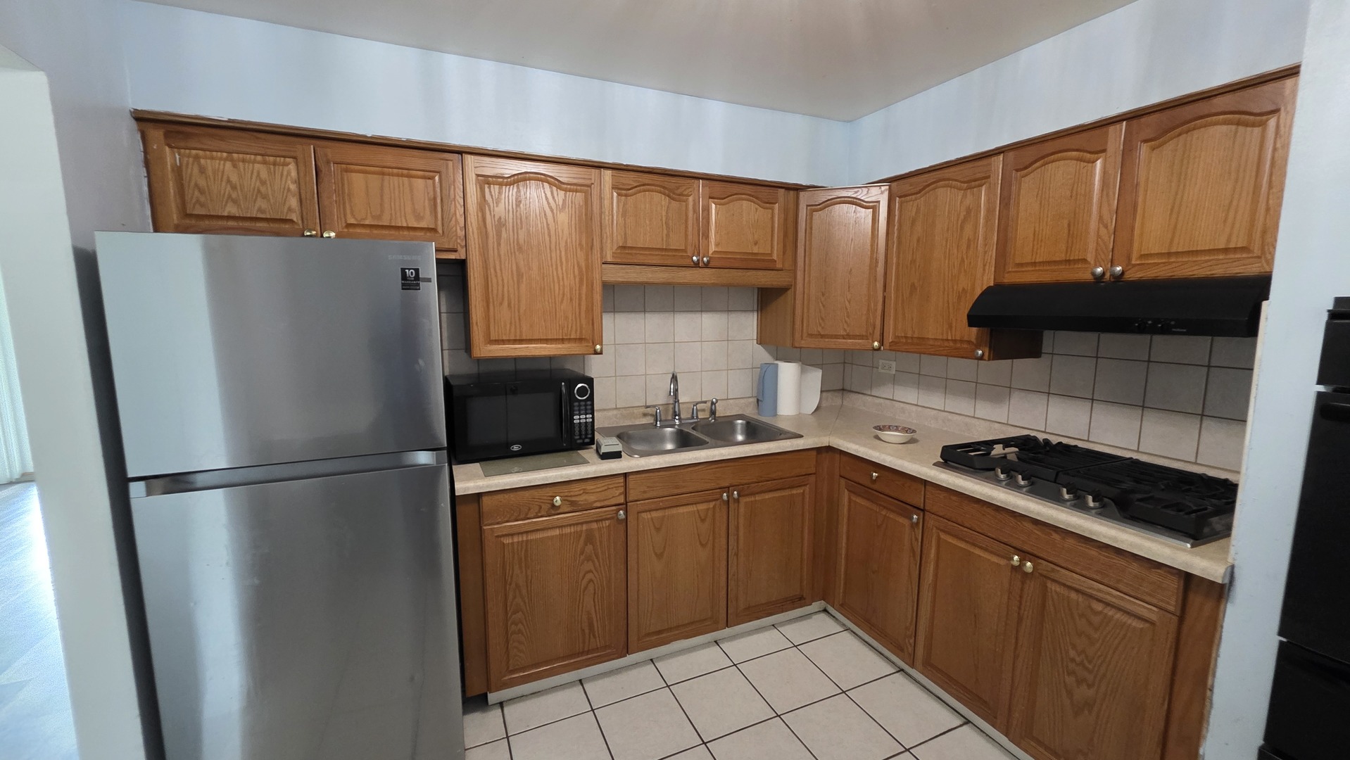 9446 Dee Road, Unit 2E Des Plaines, IL 60016 - Photo 31 of 37 a kitchen with a refrigerator sink and cabinets