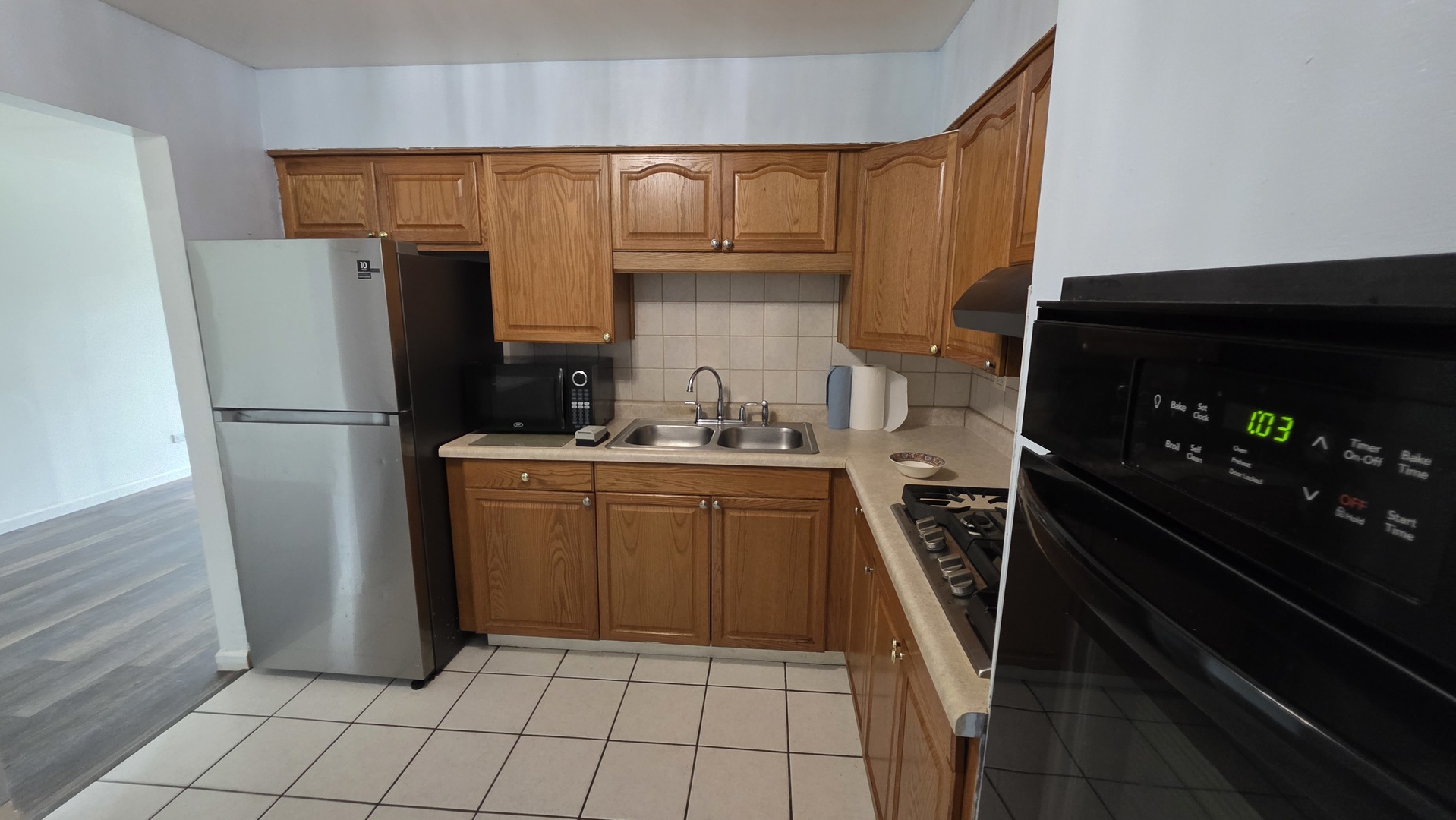 9446 Dee Road, Unit 2E Des Plaines, IL 60016 - Photo 32 of 37 a kitchen with a refrigerator sink and cabinets