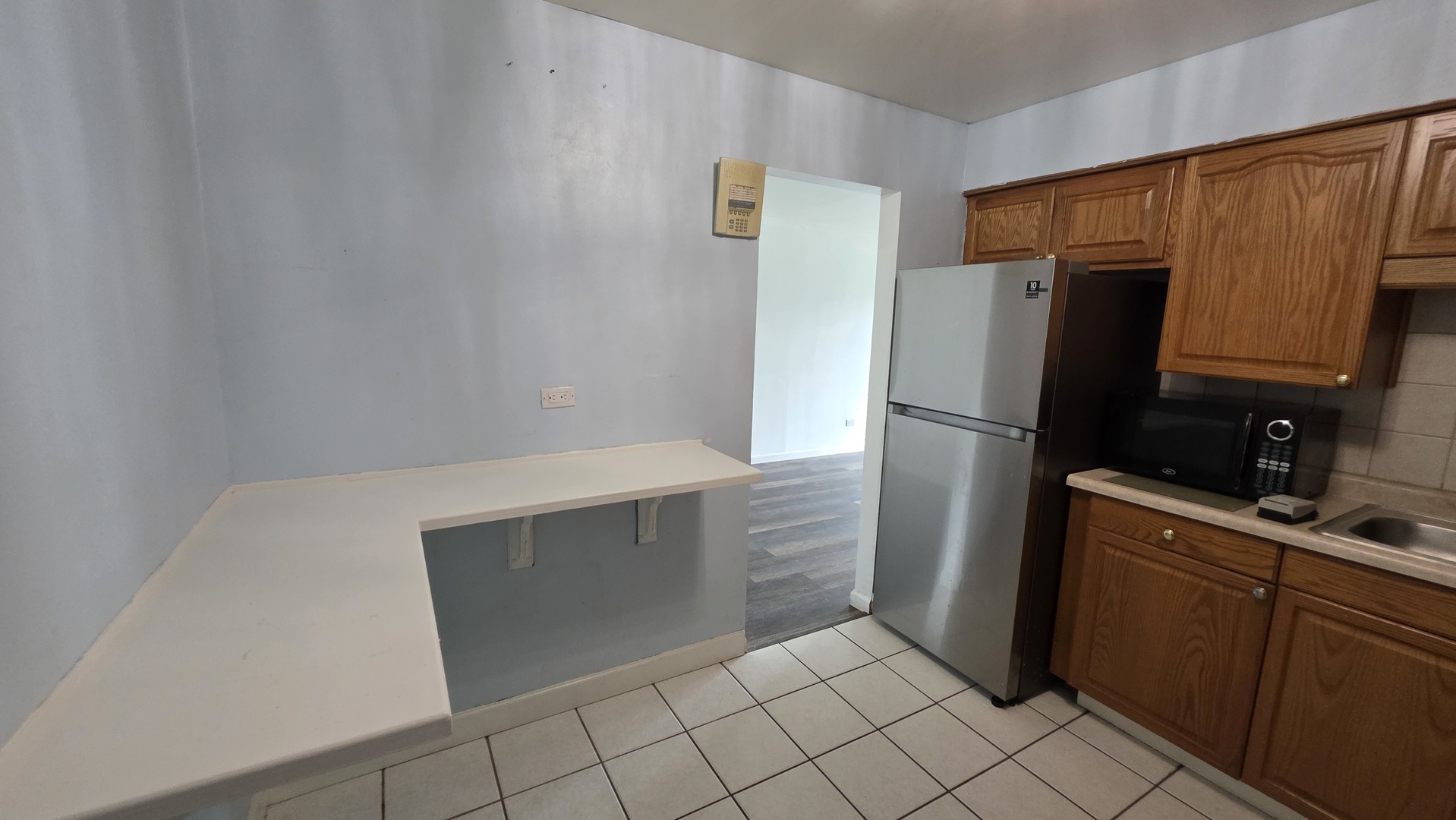 9446 Dee Road, Unit 2E Des Plaines, IL 60016 - Photo 33 of 37 a kitchen with a refrigerator and cabinets