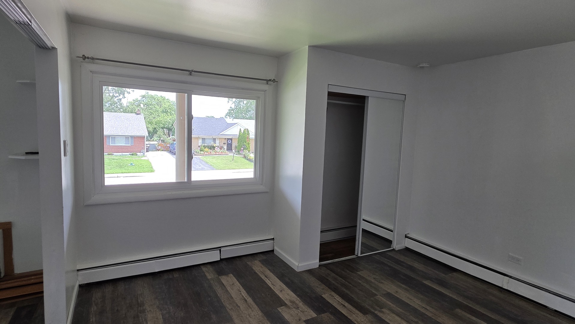 9446 Dee Road, Unit 2E Des Plaines, IL 60016 - Photo 8 of 37 a view of an empty room with wooden floor and a window