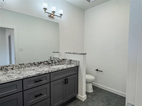 a bathroom with a granite countertop sink and shower