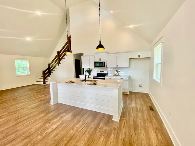 a view of kitchen with wooden floor and electronic appliances