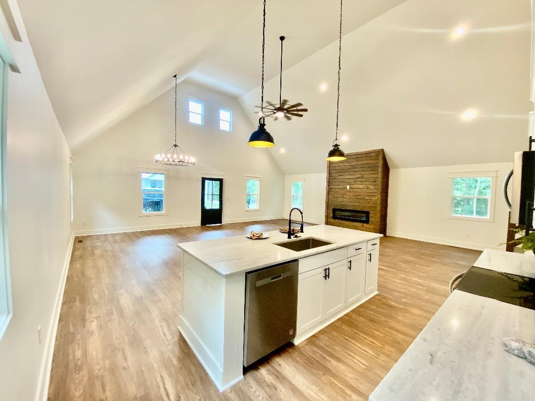 265 Rock Quarry Way Counce, TN 38326 - Photo 4 of 17 a view of a kitchen with kitchen island a sink wooden floor and living room view