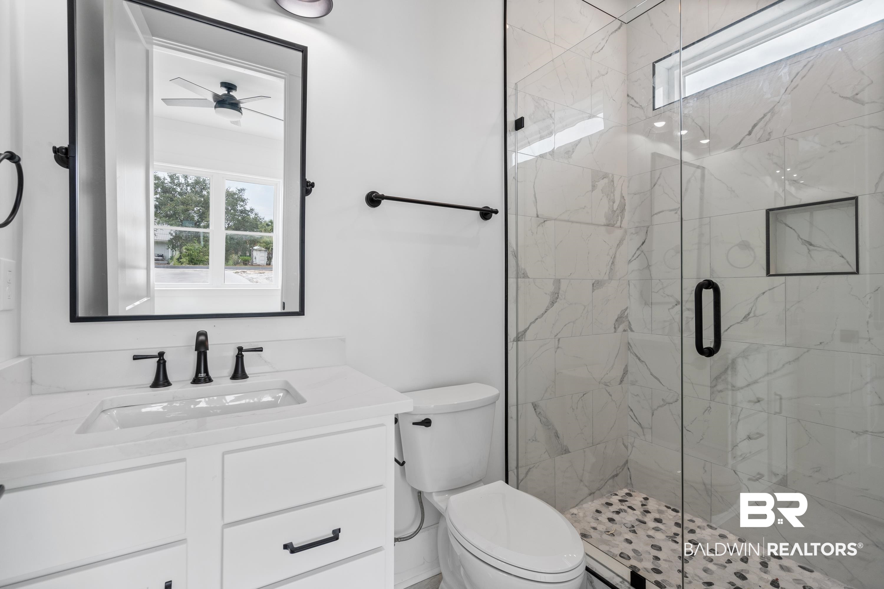 30650 Ono N Loop West Orange Beach, AL 36561 - Photo 23 of 38 Bathroom featuring toilet, a marble finish shower, vanity, and a ceiling fan