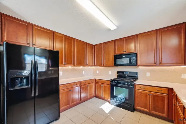 a kitchen with stainless steel appliances granite countertop a refrigerator stove top oven a sink and dishwasher