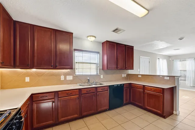 a kitchen with stainless steel appliances granite countertop a sink dishwasher stove and cabinets with wooden floor