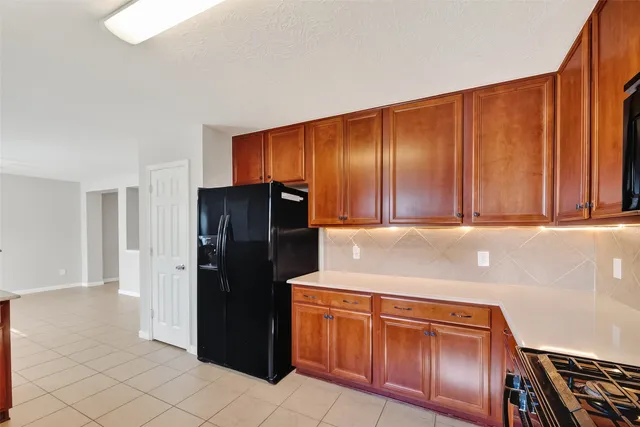 a kitchen with stainless steel appliances granite countertop a refrigerator and a stove top oven