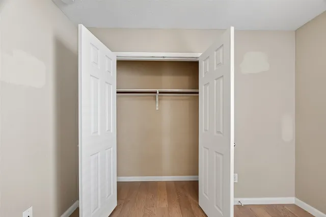 a view of walk in closet with wooden floor