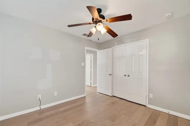 an empty room with closet and wooden floor