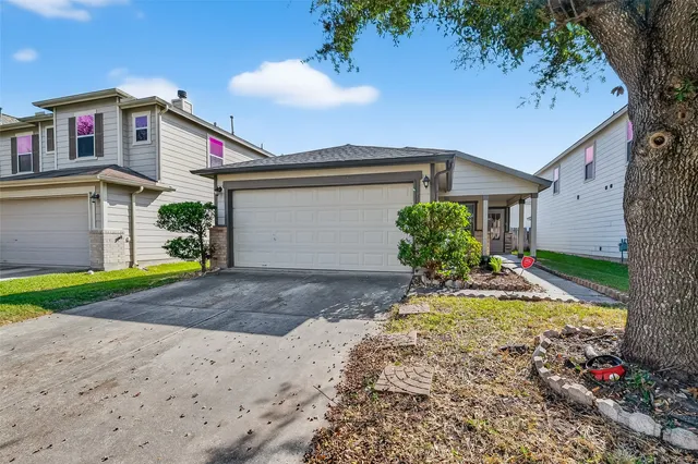 a view of a house with small yard and a large tree