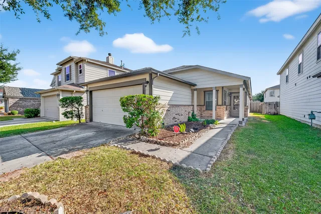 a front view of a house with a yard and potted plants