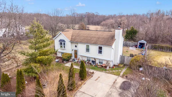 an aerial view of a house with a yard and mountain view in back
