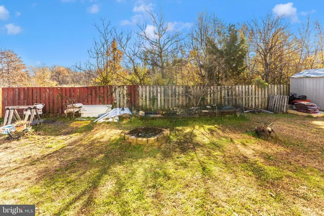 a view of backyard with wooden fence and trees