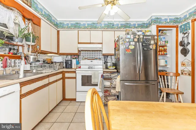 a kitchen with stainless steel appliances kitchen island granite countertop a refrigerator and a sink