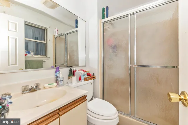 a bathroom with a sink vanity mirror and toilet