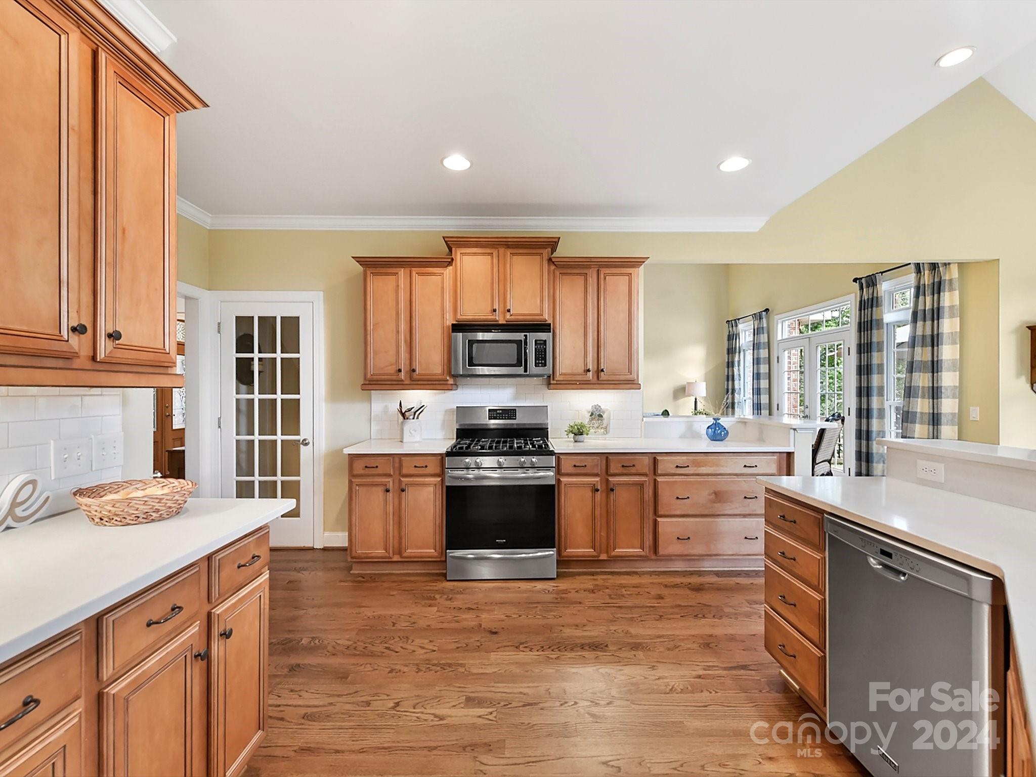 146 Canterbury Crossing Fort Mill, SC 29708 - Photo 13 of 48 a kitchen with stainless steel appliances granite countertop a stove a sink dishwasher and a microwave oven with white cabinets