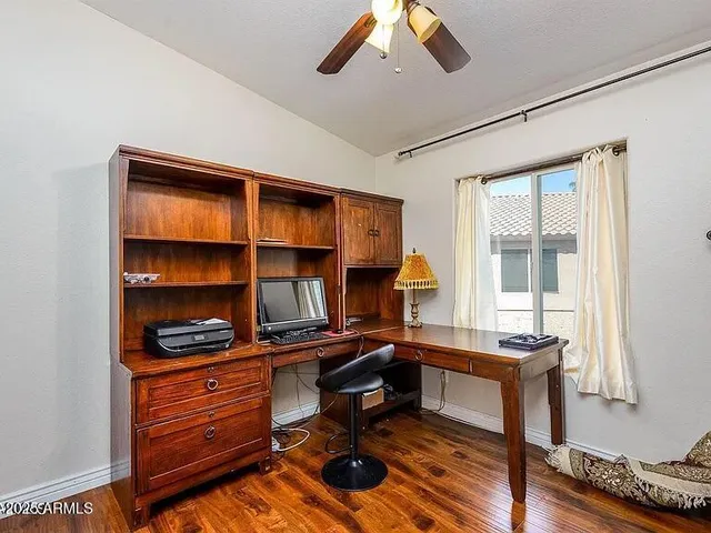 a view of a workspace with furniture and a window