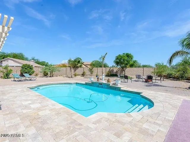 a swimming pool with outdoor seating and yard