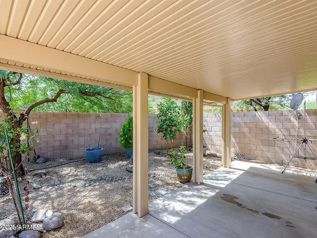 a backyard of a house with a garden and outdoor seating