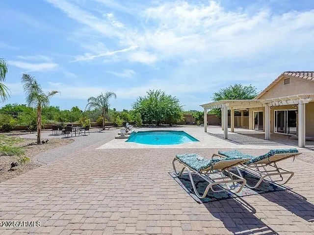 a view of a house with swimming pool and sitting area