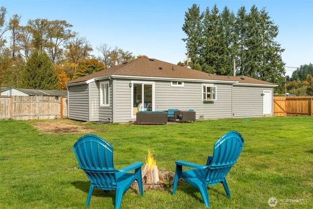 a view of a house with backyard and sitting area