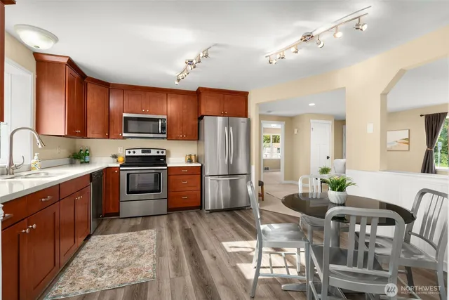 a kitchen with granite countertop a refrigerator stove top oven and sink