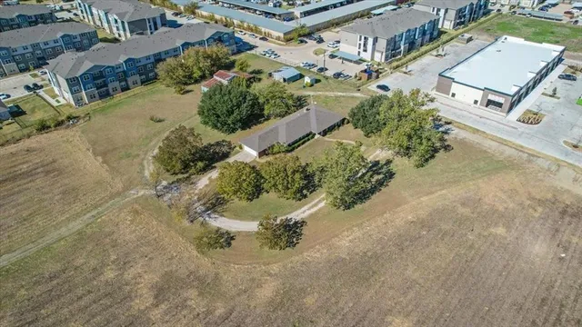 an aerial view of a house with a yard and street