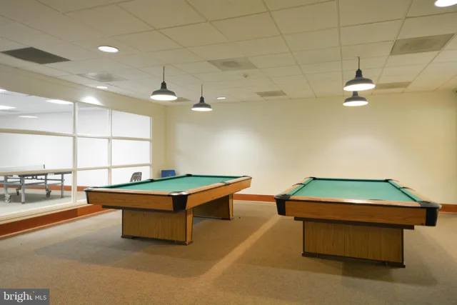 a room with pool table and windows