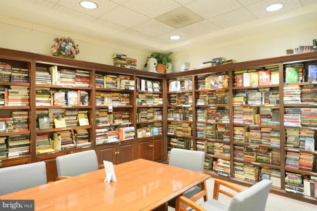 a room with lots of tables a large window and chairs