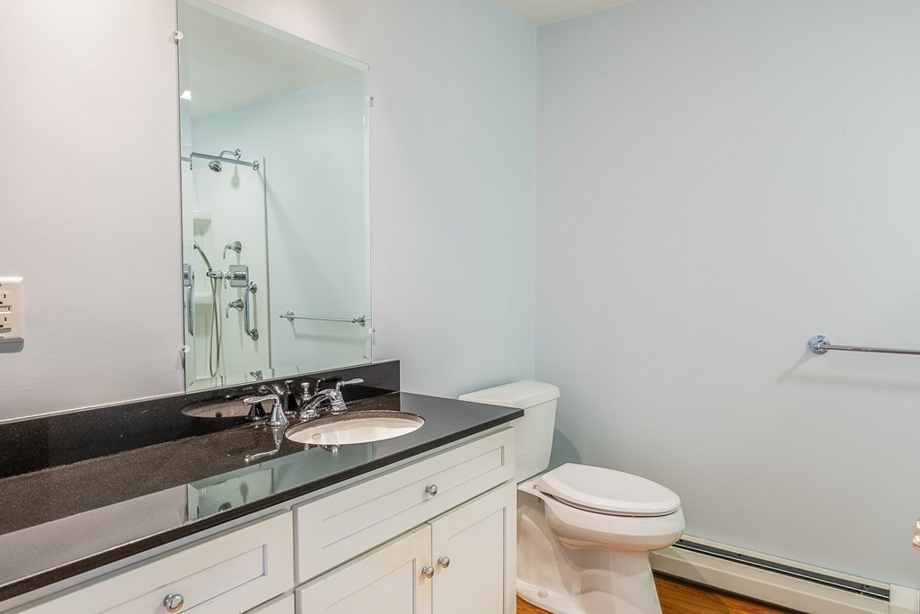 147 Front Street, Unit 6 Marblehead, MA 01945 - Photo 14 of 25 a bathroom with a granite countertop sink a toilet and a mirror