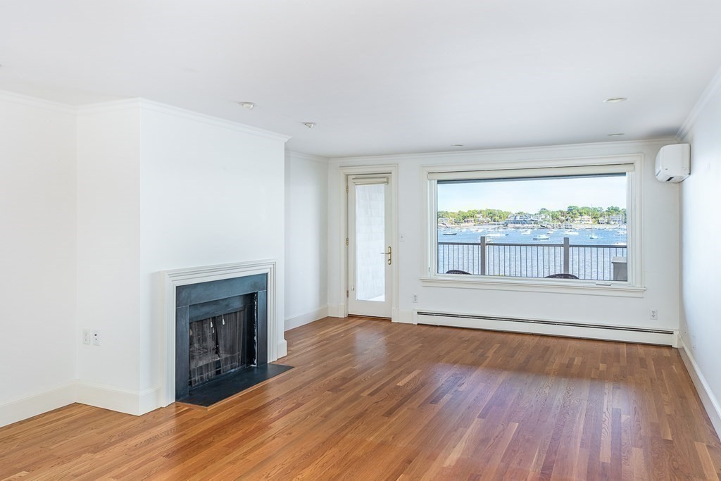 147 Front Street, Unit 6 Marblehead, MA 01945 - Photo 4 of 25 a view of empty room with wooden floor and fireplace