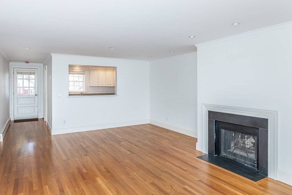 147 Front Street, Unit 6 Marblehead, MA 01945 - Photo 6 of 25 an empty room with windows and fireplace