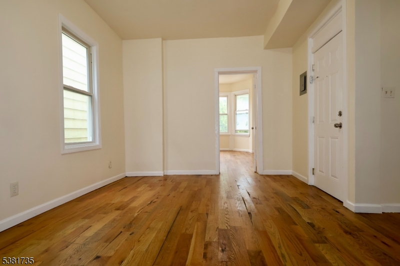 112 Chadwick Avenue, Unit 2 Newark, NJ 07108 - Photo 4 of 13 a view of an empty room with wooden floor and a window
